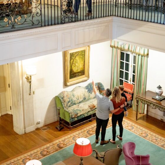 A family of three looking at a piece of art in a reception hall.