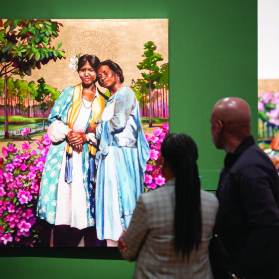 Visitors looking at "Flora and Lillie," a portrait painting by American artist Stephen Towns
